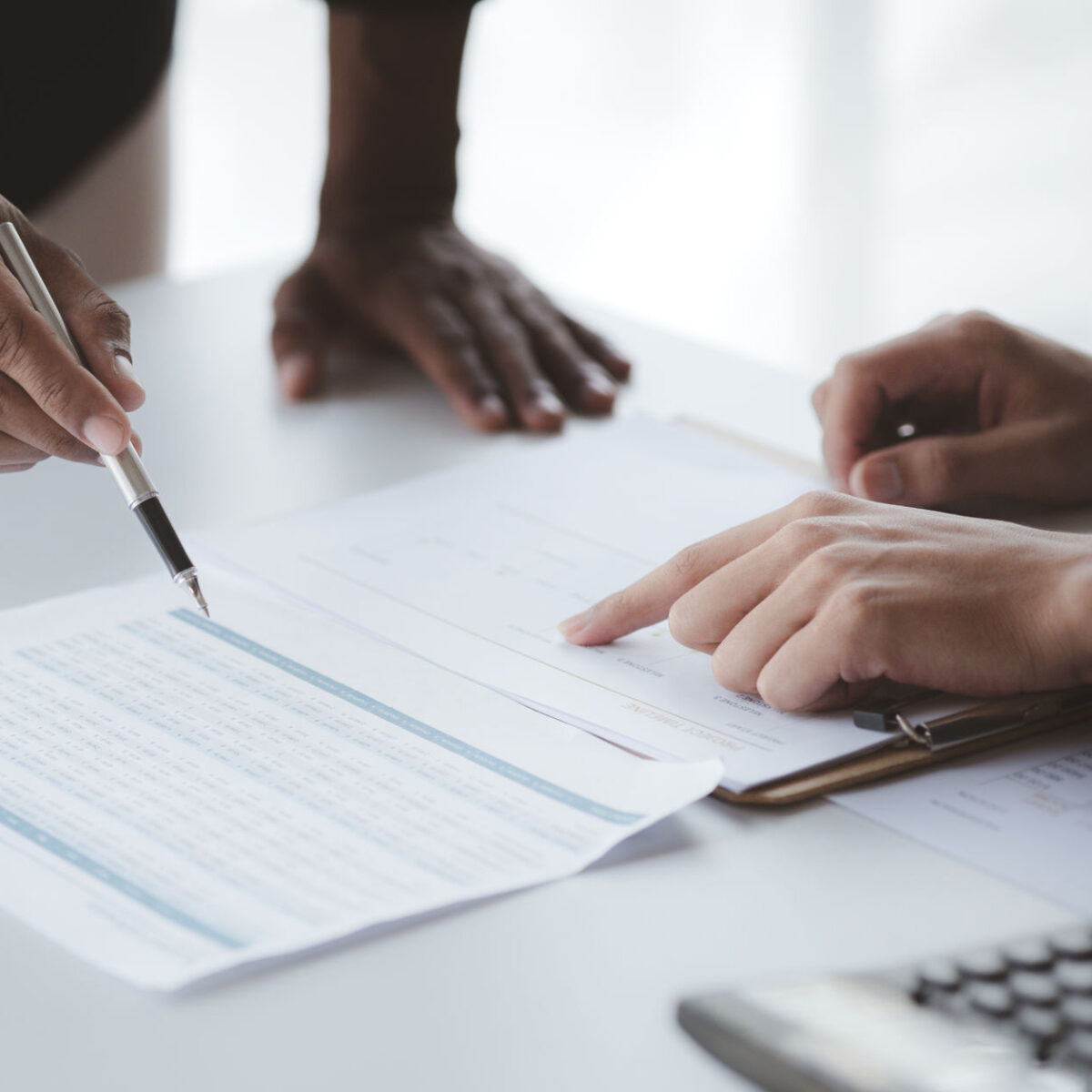 Image of auditors' hands working on paperwork